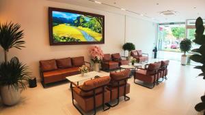 a waiting room with a couch and tables and chairs at ARIA Hotel in Ninh Binh