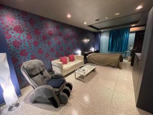 a living room with a couch and a bed at ホテル アクティ エクシブ in Asahi