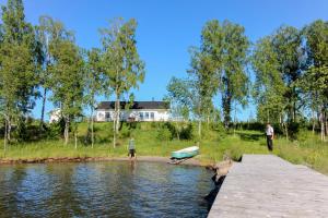 a couple of people standing on a dock with a boat at Villa Björkholmen in Svartön