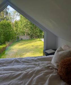 a bedroom with a large window looking out at a yard at Halsmo 6 in Kil
