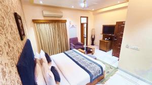 a hotel room with a bed and a television at Buddha Heritage in Patna