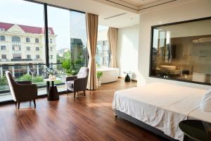 a bedroom with a large bed and a large window at ARIA Hotel in Ninh Binh