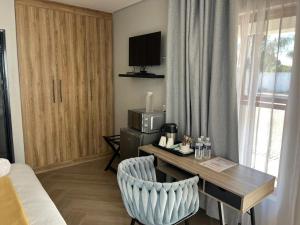a hotel room with a desk and a bed at Black Villa Lodge in Hammanskraal