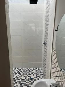a bathroom with a shower with a black and white tiled floor at Black Villa Lodge in Hammanskraal +11 photos