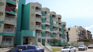 ein Gebäude mit davor geparkten Autos in der Unterkunft Apto Ingleses à 50mts da praia in Florianópolis