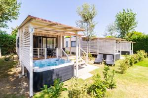 a tiny house with a hot tub in the yard at Ca' Berton Village in Cavallino-Treporti