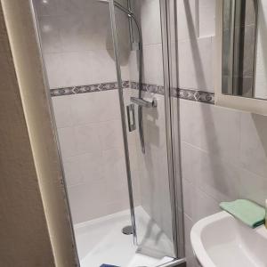 a shower with a glass door next to a sink at Ferienappartment Op n böhn in Nordstrand
