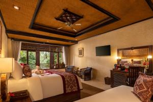 a bedroom with a bed and a living room at Hotel Tjampuhan Spa in Ubud