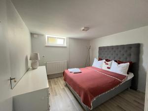 a bedroom with a bed with red sheets and white pillows at Joselia in Falkenberg
