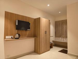 a room with a cabinet with a flat screen tv at Kovil Vaasam in Tiruchirappalli