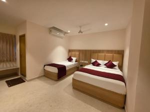 a hotel room with two beds in a room at Kovil Vaasam in Tiruchirappalli