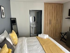 a bedroom with a large bed and a mirror at Black Villa Lodge in Hammanskraal