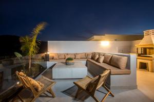 a living room with a couch and a table and chairs at Celeste Luxury Villas in Lartos