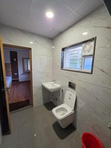 a bathroom with a toilet and a sink at Kovil Vaasam in Tiruchirappalli