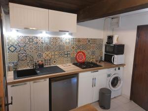 a kitchen with a stove and a washing machine at Maisonnette de caractère au calme in Fayence