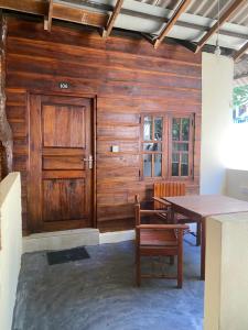 a wooden room with a table and a wooden door at Leaf Villa in Arugam Bay