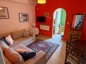 a living room with a couch and a red wall at Art & Motion Union - Guest Room 3 in Apoíkia