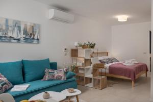 a living room with a blue couch and a bed at Desamani 975 in Kostrena
