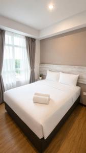 a bedroom with a large white bed with a window at The Leverage Lite (Kuantan) in Kuantan