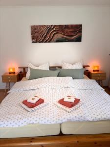 a white bed with two towels on top of it at Haus Auerhahn Ferienwohnungen in Ramsau