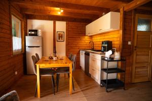 a small kitchen with a table and a refrigerator at DOMKI POD JARZĘBINĄ in Puck +35 photos