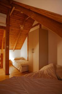 an attic bedroom with two beds and a cabinet at DOMKI POD JARZĘBINĄ in Puck