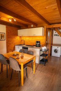 a kitchen with a table and chairs in a room at DOMKI POD JARZĘBINĄ in Puck
