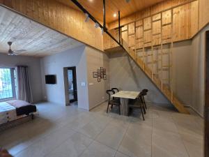 a room with a staircase and a table and a bed at Lofted Peaks in Pālampur