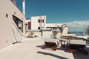 a patio with two chairs and a pool on a building at Orien, Seaside Luxury Villa in Argassi