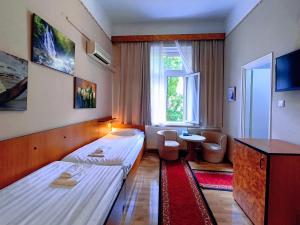 a hotel room with two beds and a window at Villa Kristal Hotel in Budapest