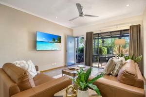 a living room with a couch and a large window at Pearl Escape in Broome