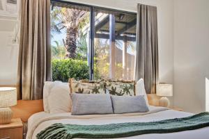 a bedroom with a bed with a large window at Pearl Escape in Broome +18 photos