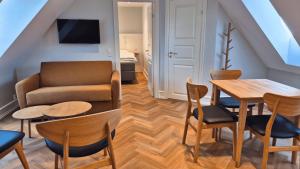 un soggiorno con divano, tavolo e sedie di Jacobs Hotel a Ringkøbing