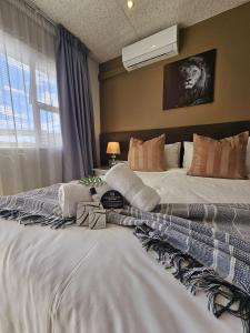 a bedroom with a large white bed and a window at Lion Lodge in Bloemfontein +54 photos