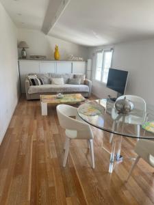 a living room with a glass table and a couch at La Petite Maison de Jane in Reims