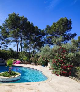 a swimming pool in a yard with trees at Villa Coronille calme et nature in Entrecasteaux