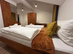 a bedroom with two beds with white sheets and yellow pillows at Apartmenthaus Zeuthen 1 in Zeuthen