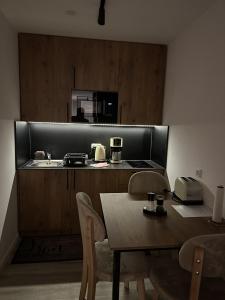 a kitchen with a table and a sink and a counter at Apartmenthaus Zeuthen 1 in Zeuthen