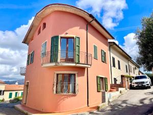 a pink building with a balcony on a street at Villa Soprana by Agenzia SolturElba in Capoliveri