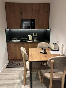 a dining room with a table with chairs and a microwave at Apartmenthaus Zeuthen 1 in Zeuthen