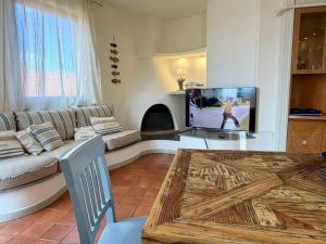 a living room with a couch and a tv at Villa Soprana by Agenzia SolturElba in Capoliveri