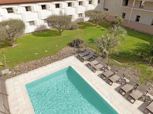 an overhead view of a swimming pool with chairs and a building at ibis Aix en Provence in Aix-en-Provence