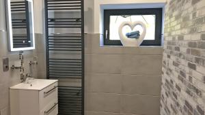 a bathroom with a sink and a window with a heart drawn on a windowtaining at Fewo Carpe Diem in Scheuerfeld +14 photos