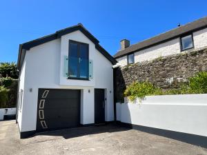 a white garage with a black door at Coachhouse in St Ives