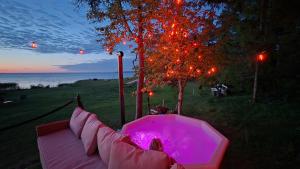 a hot tub sitting under a tree next to the water at LuigeLaguun in Triigi