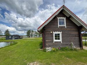 a small house with a window on a grass field at Šarkos sodyba in Miežonys +14 photos