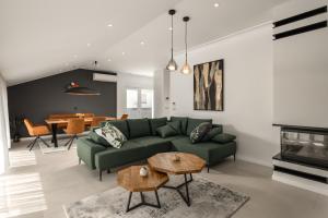 a living room with a green couch and a table at Desamani 975 in Kostrena
