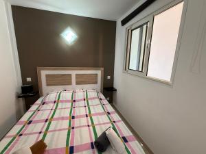 a bedroom with a bed with a multicolored quilt at AwayDays - Apartamento en la 7a planta vista mar! in Empuriabrava