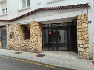 an entrance to a building with a stone wall at Appartement Centre in Lourdes +2 photos