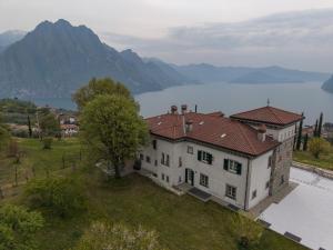an aerial view of a house with a lake and mountains at Villa Hélène in Solto Collina